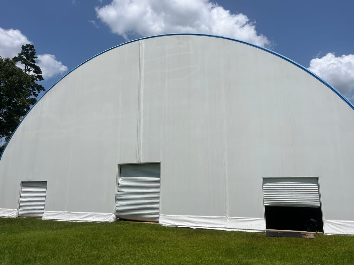 Large curved commercial exterior shown from ground level after high-access cleaning work.